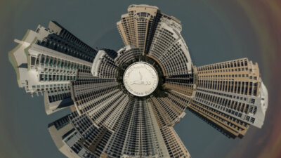 a 360-view of Dubai's high rise building surrounding an Emirati dirham at the center